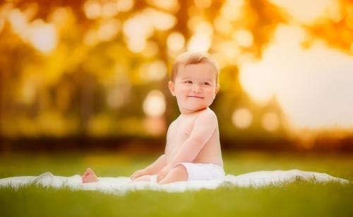 Baby sitting outdoors on a blanket